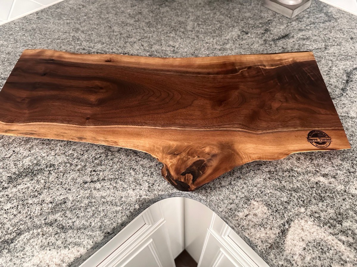 Handcrafted live-edge walnut charcuterie board on granite countertop