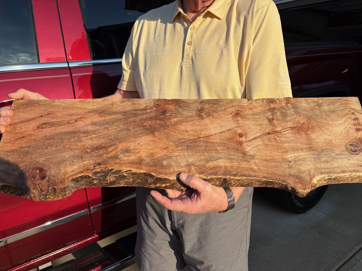 Steve holding a hand-selected burl wood charcuterie board
